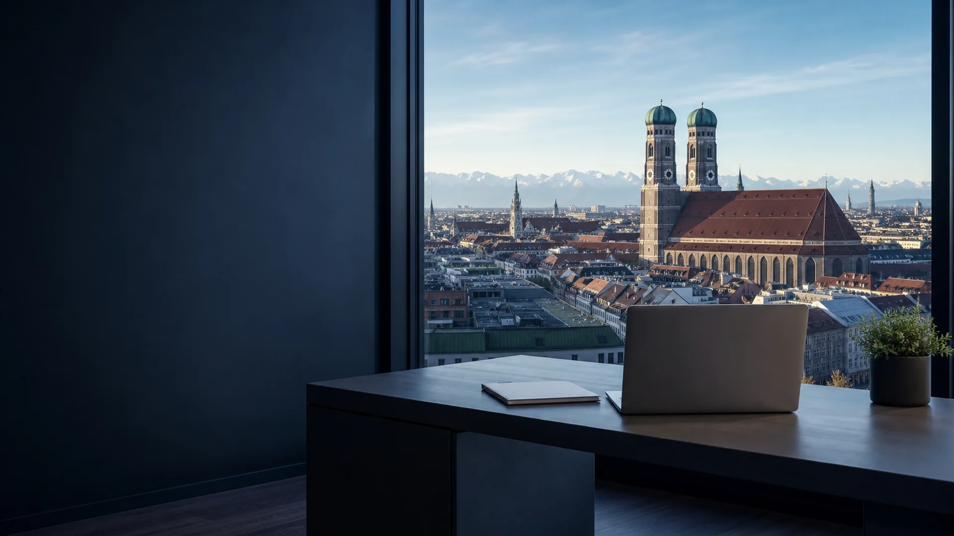Münchner Skyline mit Frauenkirche im Hintergrund und Laptop-Arbeitsplatz im Vordergrund