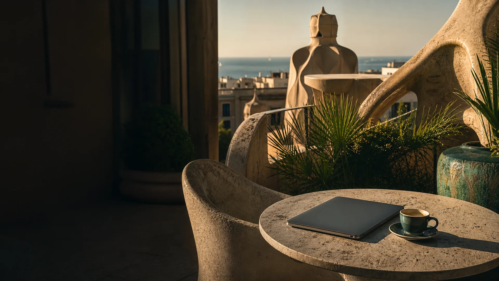 Moderner Co-Working-Space mit Blick auf das Mittelmeer in Barcelona – Laptop und Kaffee auf Terrasse